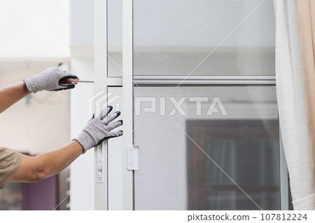 Construction worker repairing the sliding window. 107812224