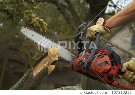 The chainsaw was firmly in the hand of the individual 107813252
