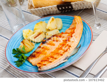 Baked trout fillet with potatoes Baked trout fillet with potatoes 107813482