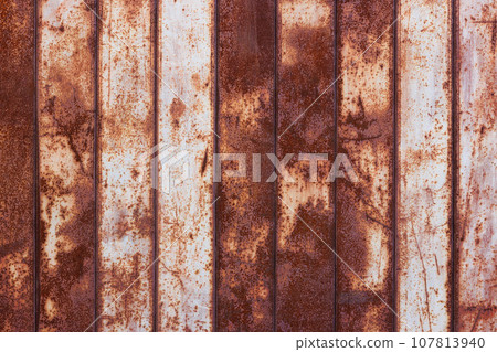 flat texture of rusty corrugated flat thin sheet metal surface with vertical structure and leftovers of white paint 107813940
