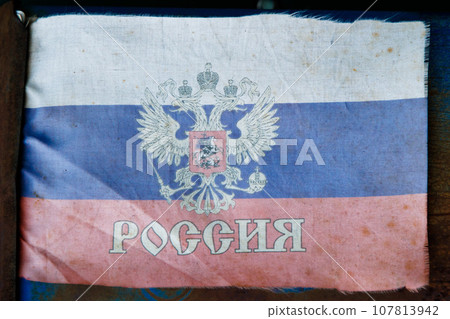 extremely faded small fabric russian flag with with coat of arms 107813942