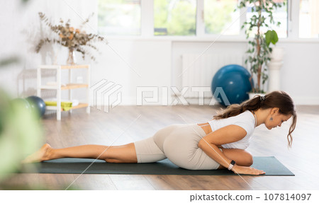 Persistent female doing yoga at gym. Various yoga poses on a mat in gym Persistent female doing yoga at gym. Various yoga poses on a mat in gym 107814097