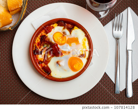 Huevos con chistorra. Scrambled eggs with sausage and potatoes 107814128