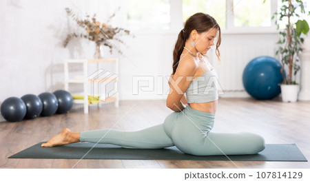 Woman wearing sportwear doing Yoga exercise,Yoga One Legged King Pigeon pose or Eka Pada Rajakapotasana, calm of healthy woman breathing and meditation with yoga 107814129
