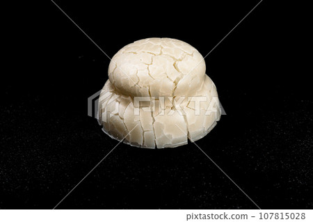 Kagami biraki cracked kagami mochi on black background Kagami biraki cracked kagami mochi on black background 107815028