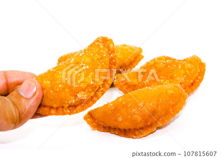 Gujiya on white background with selective focus Gujiya on white background with selective focus 107815607
