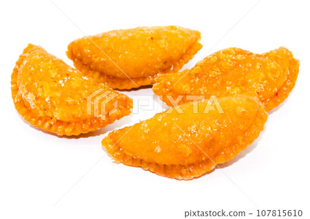 Gujiya on white background with selective focus Gujiya on white background with selective focus 107815610
