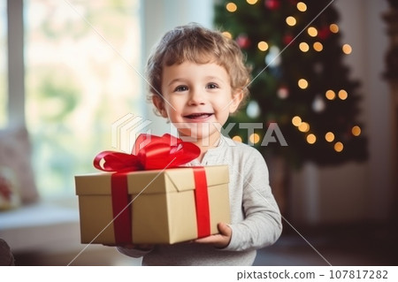 Photo of a Happy little smiling girl with christmas gift box 107817282