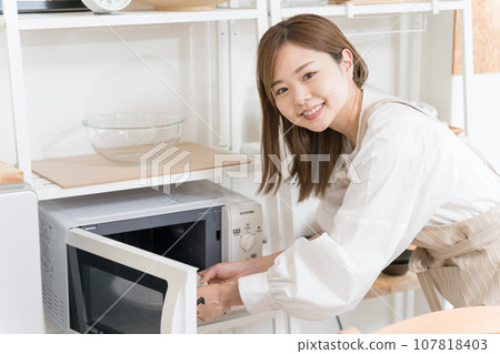 使用微波爐的年輕女子 使用微波爐的年輕女子 107818403