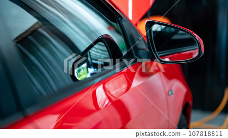 Side rear view window on the new red modern car. Side rear view window on the new red modern car. 107818811