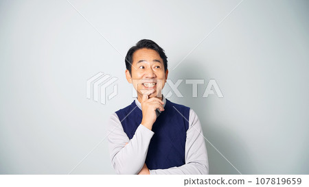 Middle-aged man thinking happily Middle-aged man thinking happily 107819659
