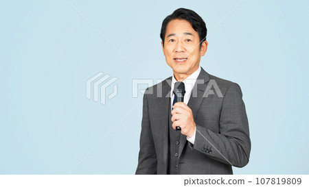 Middle-aged man speaking with a microphone 107819809