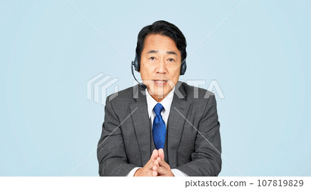Middle-aged man wearing a headset and talking 107819829