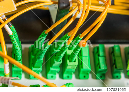 detail of server rack with fiber optic cables attached to front panel switch ports 107821065