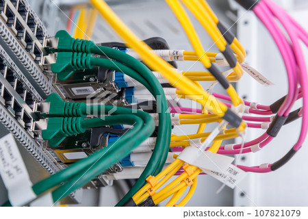 fiber optic cables connected to optic ports, network cables connected to ethernet ports fiber optic cables connected to optic ports, network cables connected to ethernet ports 107821079