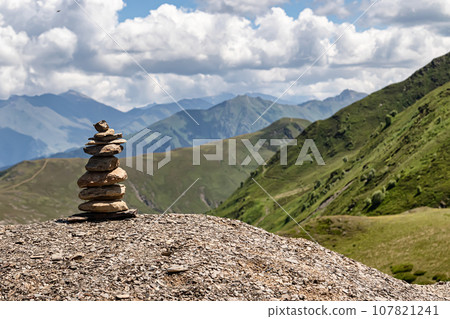 Small pebbles are made up in a tower and keep the balance, personify balance and tranquility Small pebbles are made up in a tower and keep the balance, personify balance and tranquility 107821241