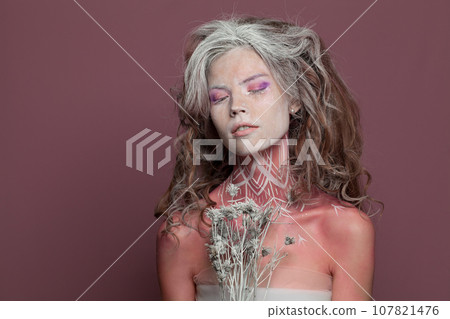 Young nice woman with makeup and pattern on her body, studio portrait 107821476
