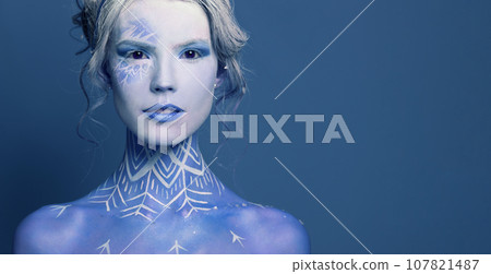 Fashion beauty portrait of cute woman with creative body art makeup on blue background  107821487