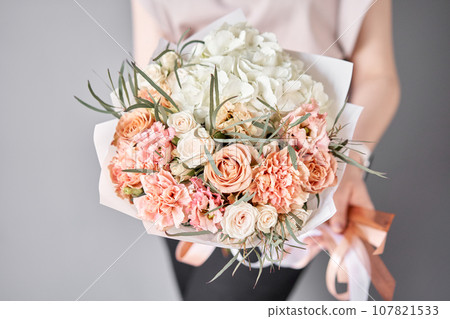 Small Beautiful bouquets of mixed flowers in woman hand. Floral shop concept . Beautiful fresh cut bouquet. Flowers delivery Small Beautiful bouquets of mixed flowers in woman hand. Floral shop concept . Beautiful fresh cut bouquet. Flowers delivery 107821533