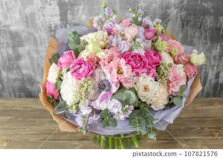 Small Beautiful bouquet of mixed flowers in woman hand. Floral shop concept . Beautiful fresh cut bouquet. Flowers delivery Small Beautiful bouquet of mixed flowers in woman hand. Floral shop concept . Beautiful fresh cut bouquet. Flowers delivery 107821576