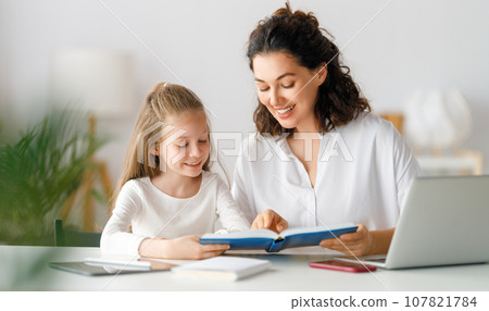 Girl doing homework or online education. Girl doing homework or online education. 107821784