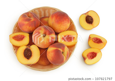 Ripe peach fruit with half in a wicker basket isolated on white background with full depth of field. Top view. Flat lay 107821797