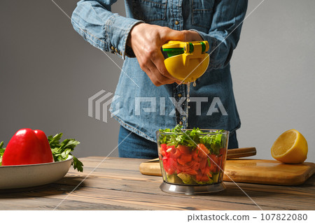 Unrecognizable woman using manual juicer to squeeze lemon into blender Unrecognizable woman using manual juicer to squeeze lemon into blender 107822080