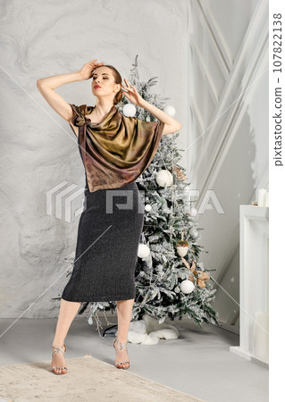 Fashion model posing with lifted arms in black dress and silk scarf Fashion model posing with lifted arms in black dress and silk scarf 107822138