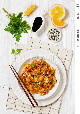 crispy orange cauliflower florets in white bowl 107822211