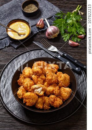 crispy fried panko breaded chicken bites in bowl 107822213