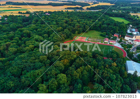 Aerial view of small european town with green park and sport field Aerial view of small european town with green park and sport field 107823013