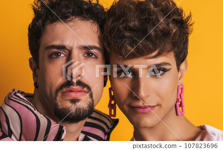 Man and trans woman in makeup looking at the camera 107823696