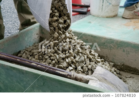 A craftsman who mixes crushed stone with mortar to mix concrete, plastering work A craftsman who mixes crushed stone with mortar to mix concrete, plastering work 107824810