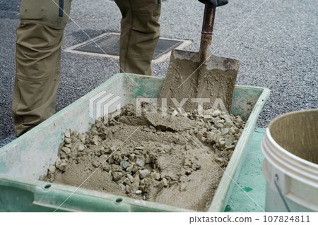 A craftsman mixes crushed stone with mortar and mixes concrete. Plastering work 02 A craftsman mixes crushed stone with mortar and mixes concrete. Plastering work 02 107824811