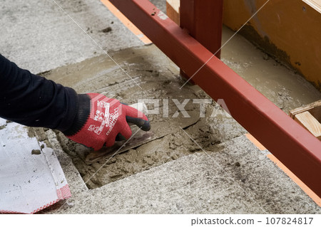 工匠為鋼框架基礎澆注混凝土並用鏝刀將其固定施工作業抹灰 02 107824817