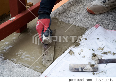 工匠為鋼框架基礎澆注混凝土並用鏝刀固定施工作業抹灰 03 107824819