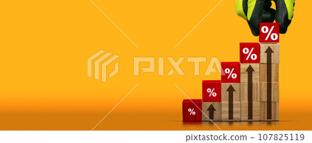 Gloved Hand Arranging Wood Blocks with Percentage Signs 107825119