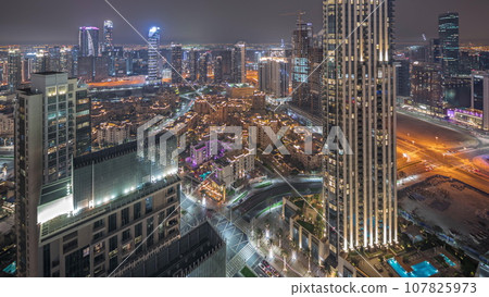 Panorama showing aerial view of a big futuristic city night timelapse. Business bay and Downtown 107825973