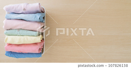 Selection of neatly folded fresh clothes for vertical storage 107826138