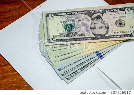 Dollars on table with an envelope. Money in an envelope. U.S. dollars. Dollars on table with an envelope. Money in an envelope. U.S. dollars. 107826917