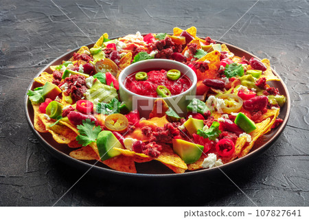 Loaded nachos. Mexican nacho chips with beef and avocado Loaded nachos. Mexican nacho chips with beef and avocado 107827641