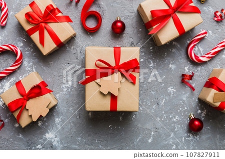 Christmas kraft gifts box with ribbon on colored background. Cozy Christmas still life, birthday or new year Christmas kraft gifts box with ribbon on colored background. Cozy Christmas still life, birthday or new year 107827911