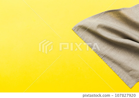 top view with gray kitchen napkin isolated on table background. Folded cloth for mockup with copy space, Flat lay. Minimal style top view with gray kitchen napkin isolated on table background. Folded cloth for mockup with copy space, Flat lay. Minimal style 107827920