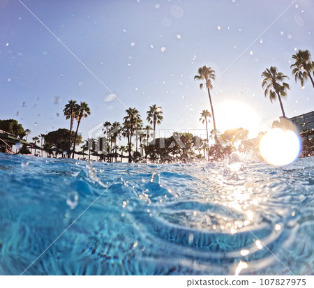 Over-under shot of hotel pool in beach resort with copy space. Beach resort vacation by the sea. Winter or summer seaside resort holiday. Over-under shot of hotel pool in beach resort with copy space. Beach resort vacation by the sea. Winter or summer seaside resort holiday. 107827975
