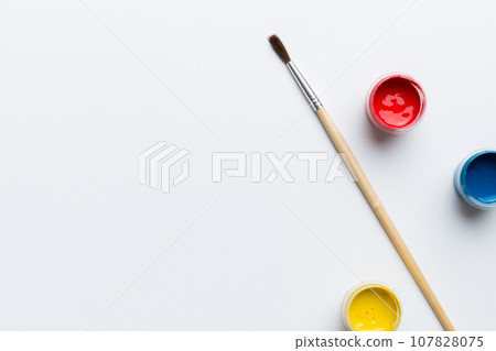 art palette with paint and brushes, close up. Top view with empty space. workplace for creativity. home teaching concept drawing 107828075