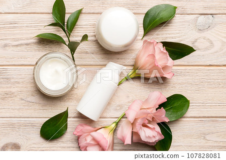 Composition with cosmetic products and beautiful roses on wooden background. Flat lay Composition with cosmetic products and beautiful roses on wooden background. Flat lay 107828081