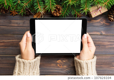 woman hands using tablet computer on wooden table bachground. cristmas shopping time. Happy Christmas mock up background, top view 107828104