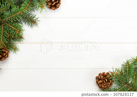 Christmas Background Christmas fir branches and pine cones on wooden white background with copy space Flat lay, top view Christmas Background Christmas fir branches and pine cones on wooden white background with copy space Flat lay, top view 107828117