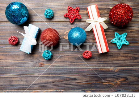 Top view Christmas ball, gift and creative decorations on wooden background. New Year holiday concept with copy space 107828135