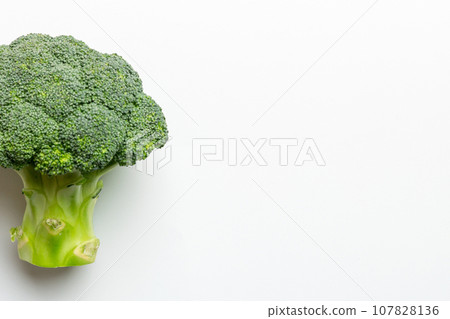 Top view fresh green broccoli vegetable on Colored background. Broccoli cabbage head Healthy or vegetarian food concept. Flat lay. Copy space 107828136